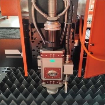 Close-up of fiber laser cutting head showing autofocus lens and nozzle design for high-precision metal sheet cutting