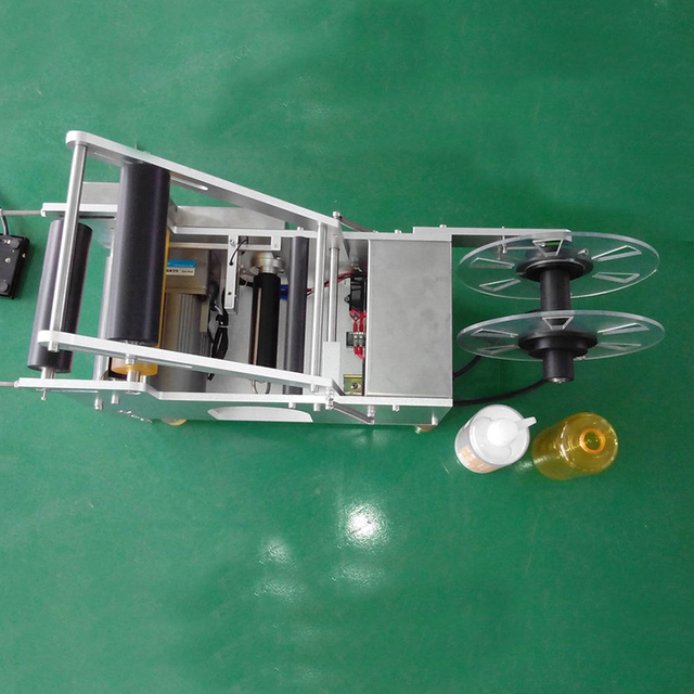Semi-auto round bottle labeling machine with compact portable design for adhesive sticker application on cylindrical bottles.