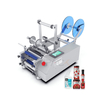 YM130 sticker labeling machine for round bottles with semi automatic operation and compact desktop structure.